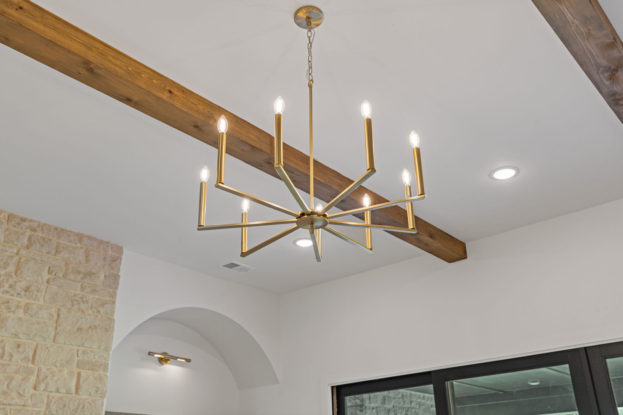Gold chandelier with exposed wood beams