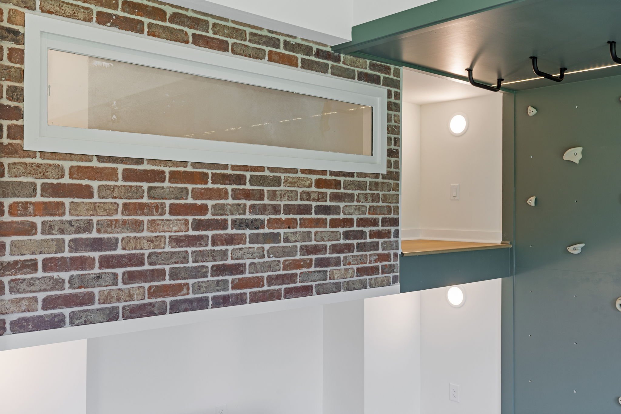 Built-in bunk room with climbing wall and brick accent