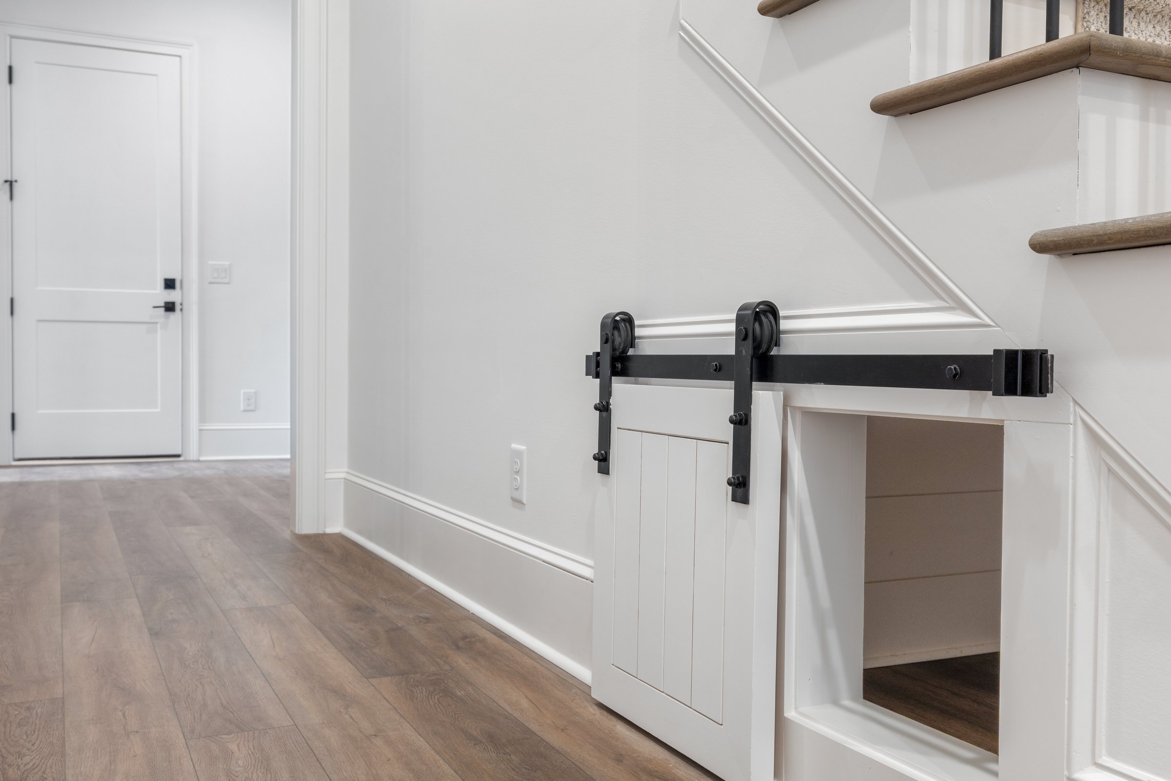 Custom under-stair dog door with barn door hardware