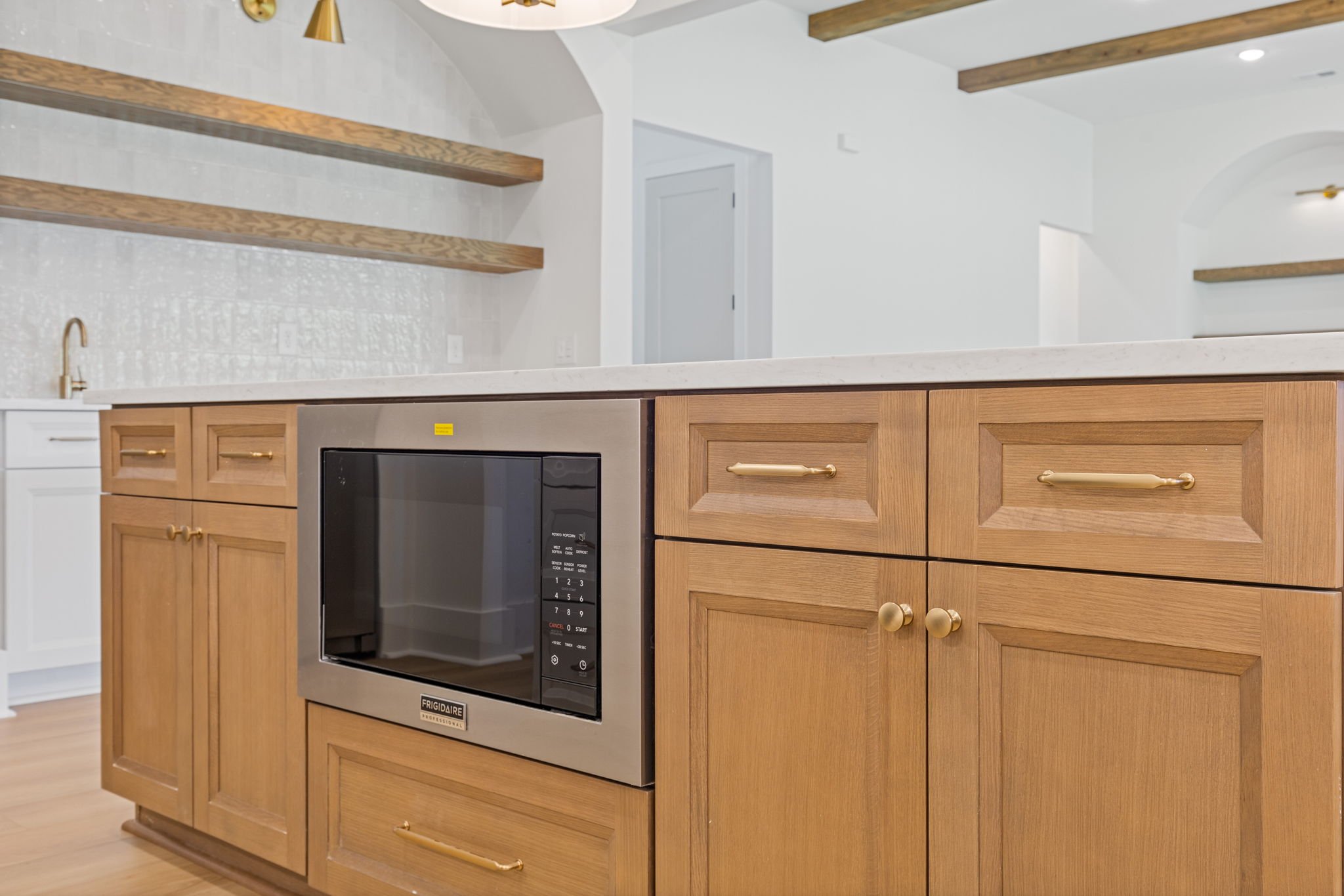 Warm wood kitchen island with gold hardware