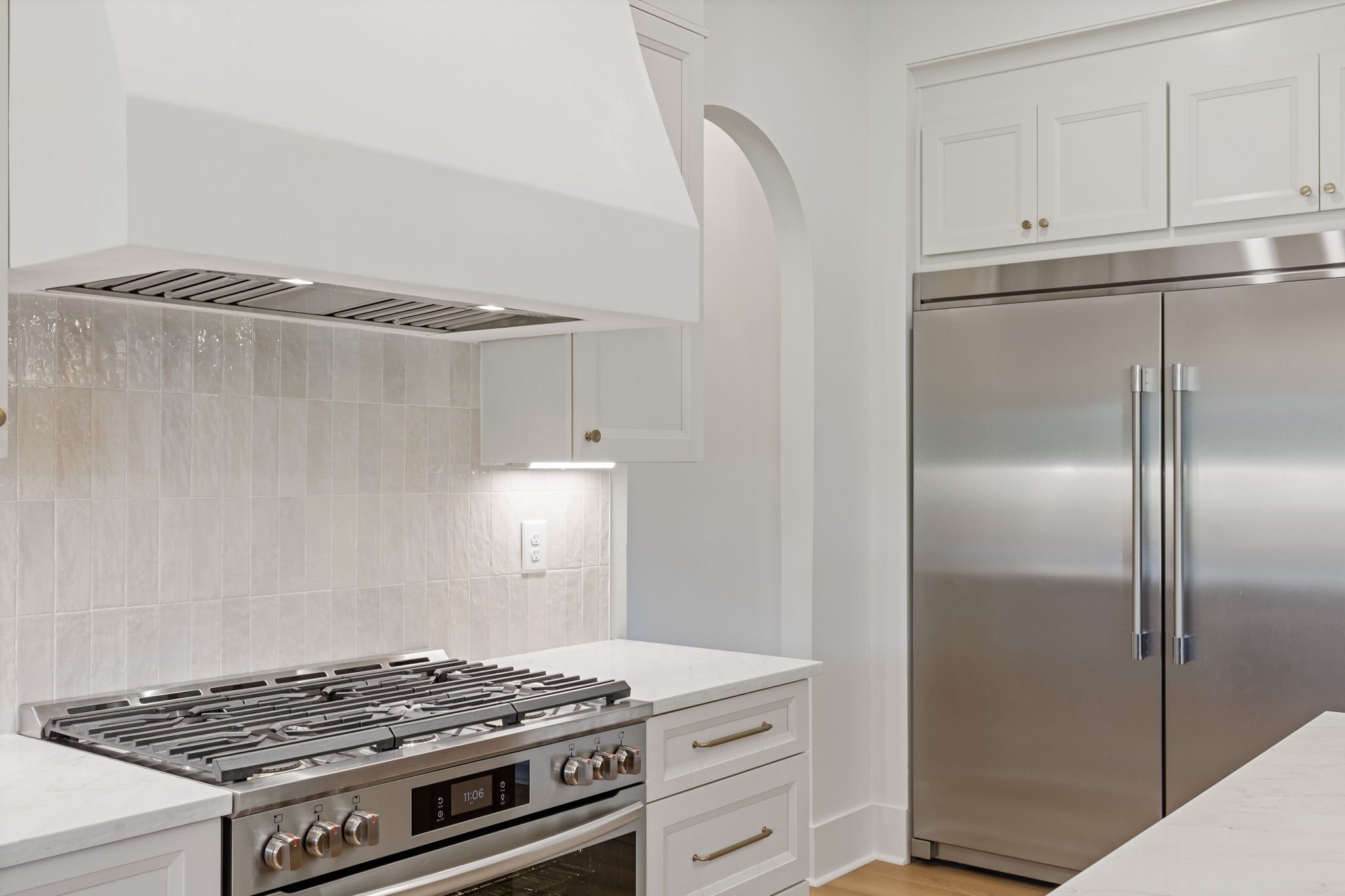 Professional range with plaster hood and subway tile