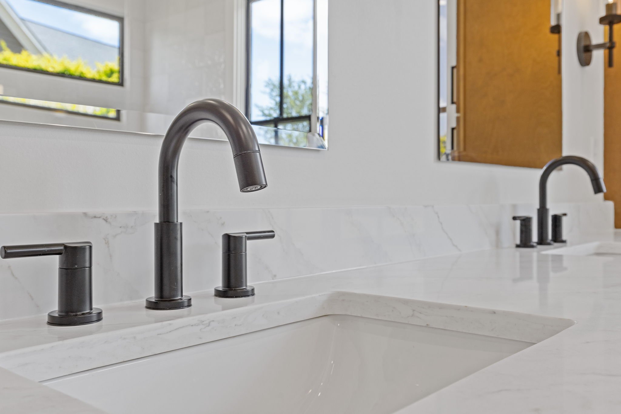 Matte black faucets on marble double vanity