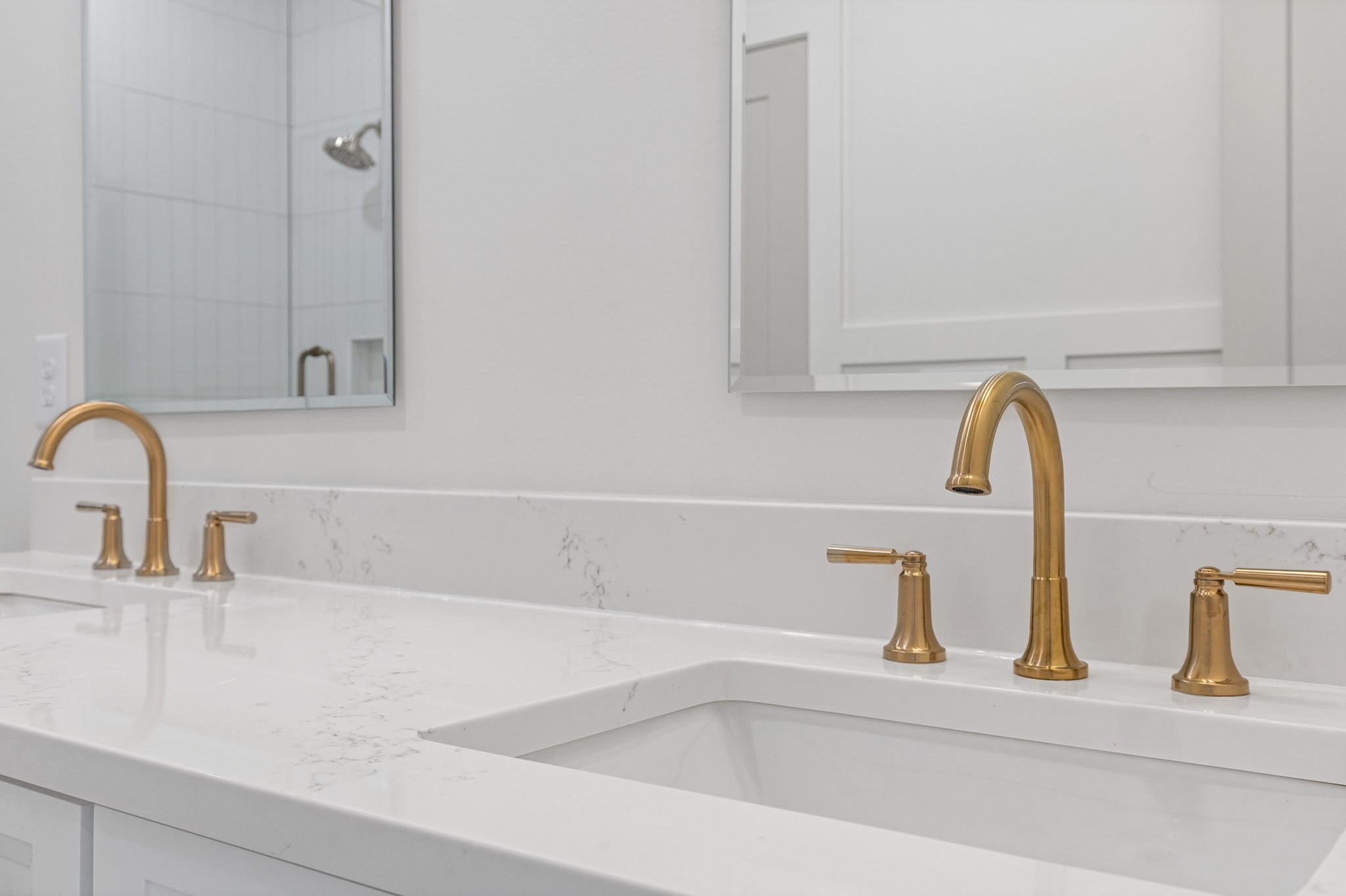Double vanity — gold faucets and marble countertop