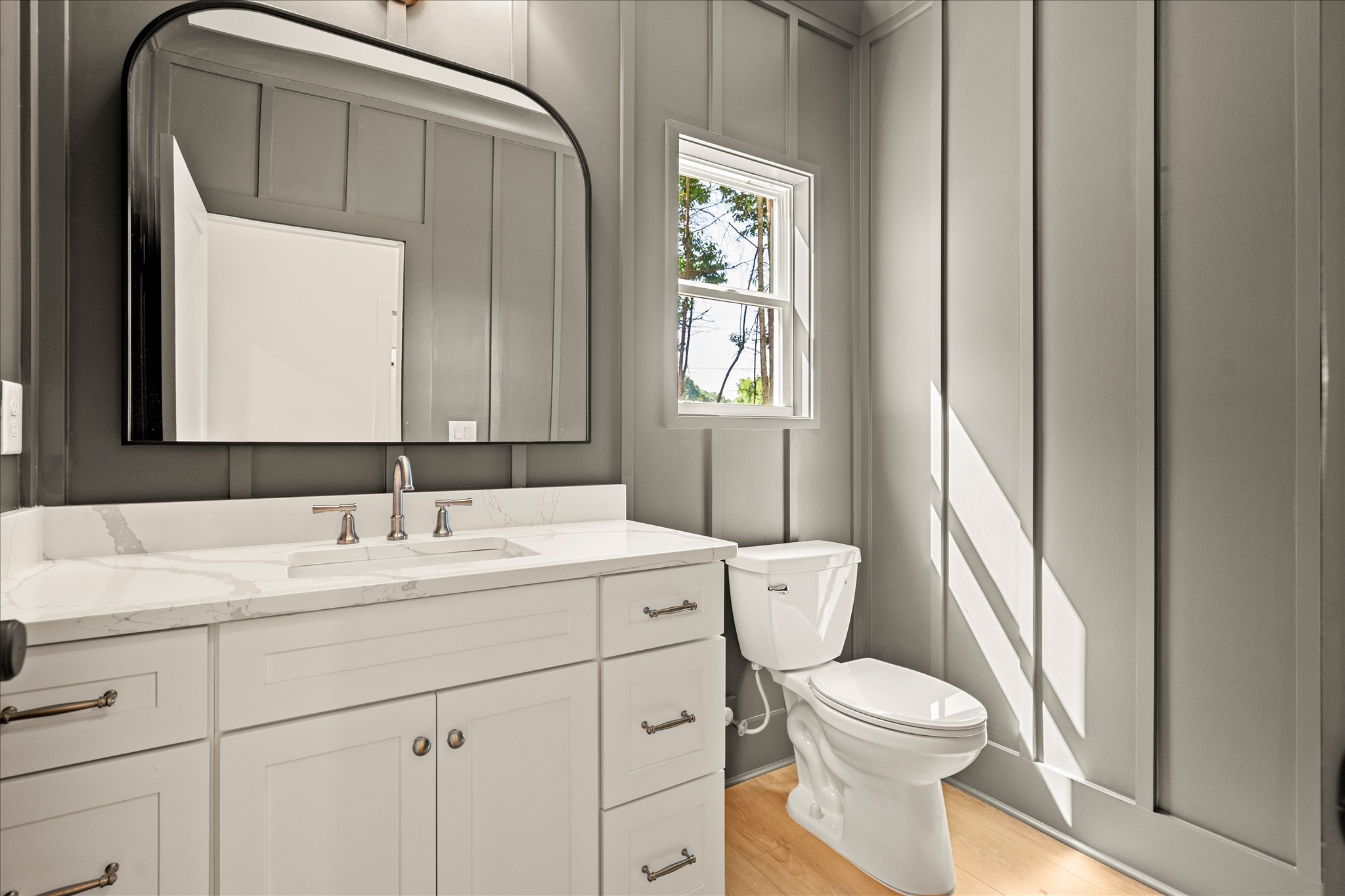 Forest and Stone — powder bath with vertical shiplap and arch mirror