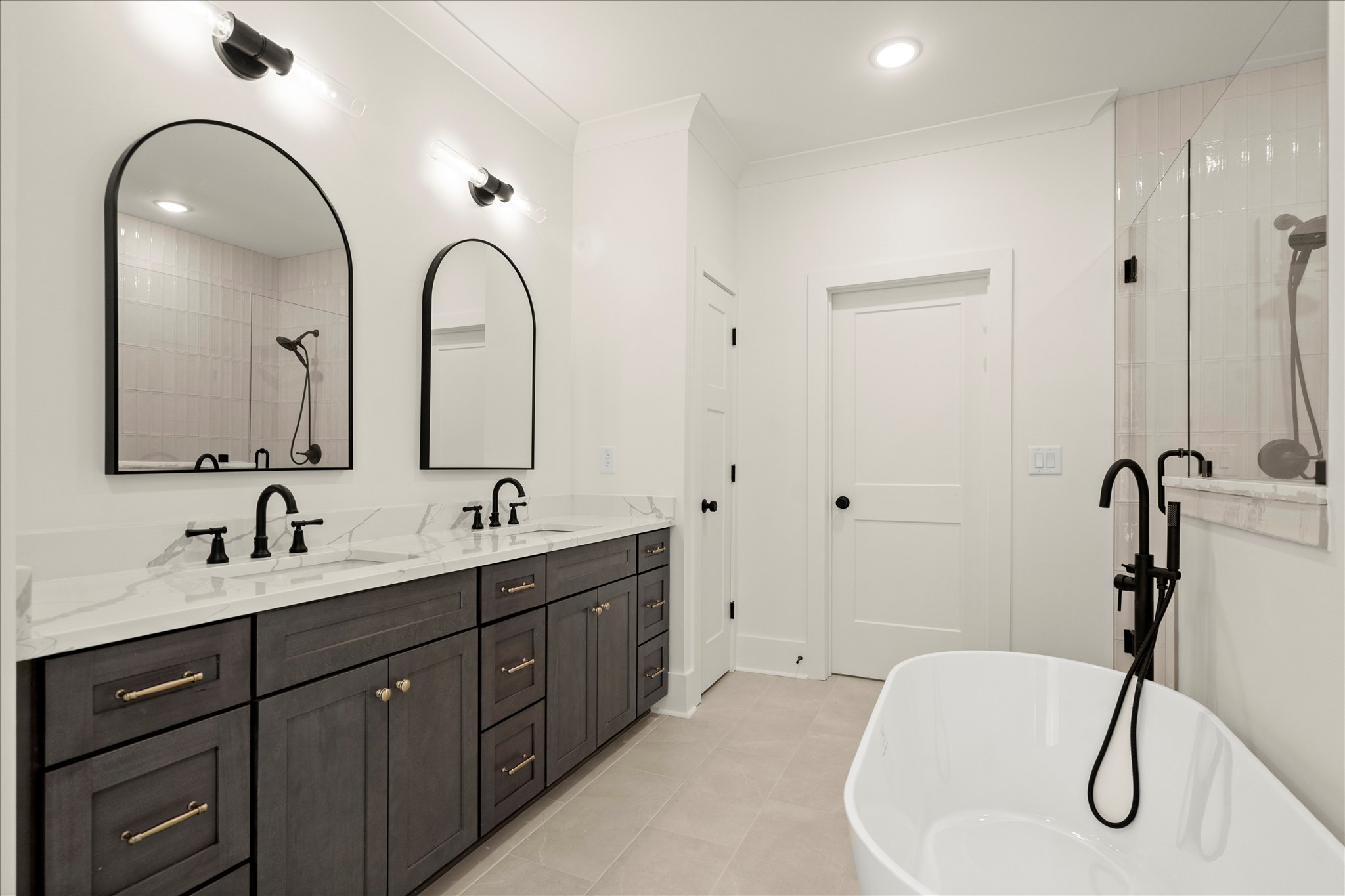 Forest and Stone — primary bath with dark vanity arched mirrors